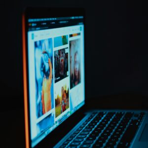 A laptop screen showing pictures in a dimly lit room, highlighting digital era browsing.