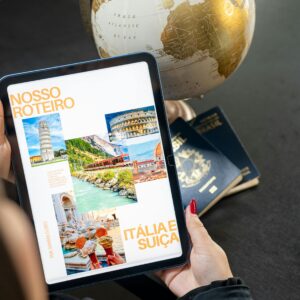 Menu Traveler planning a trip to Italy and Switzerland using a globe, tablet, and passports.